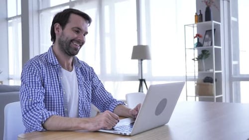 Man Working on Laptop During a Video Call
