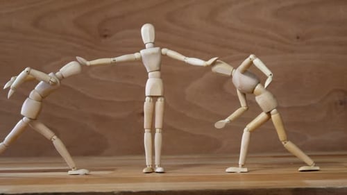 Wooden figurines referee stopping the fight on wooden backgroung