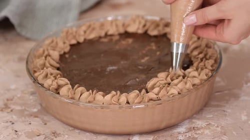 Pastry Chef Hands Squeeze Cream From a Pastry Bag Onto a Cake