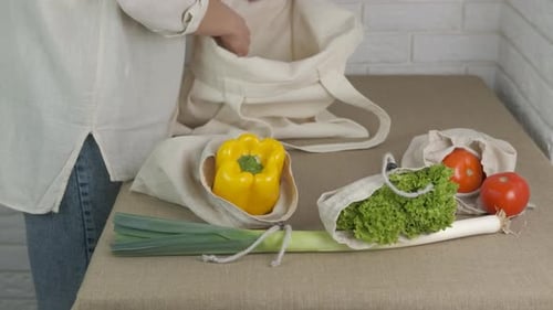 La mujer saca verduras de la bolsa