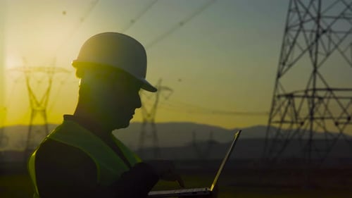 Ingenieur, der vor Strommasten arbeitet.