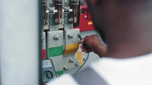 Close Up of African American Man Standing Near Switchgear Compartment with