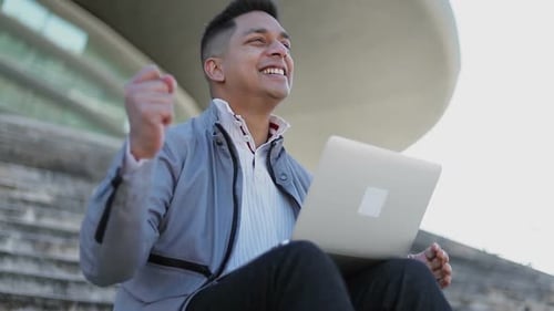 Excited Man Working on Laptop Outdoors