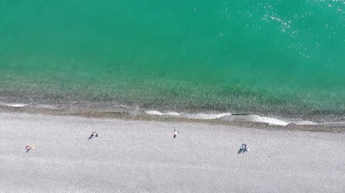 Aerial View of People Crowd Relaxing on Beach and Sea with Waves. Top View From Flying Drone