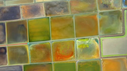 Aerial view flying over a beautiful colorful natural sea salt pond