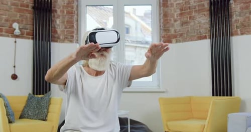 Senior Man Experiences Virtual Reality Technology at Home