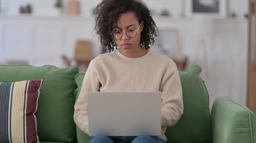 Woman Closes Laptop and Stands Up from Sofa