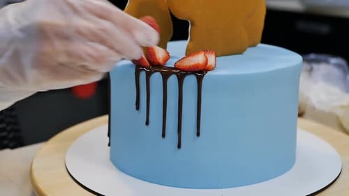 Decorating a Blue Cake with Strawberries Close Up