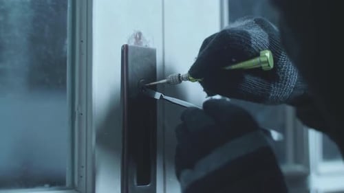 Cerca de ladrón con selector de cerraduras para abrir la puerta de una casa