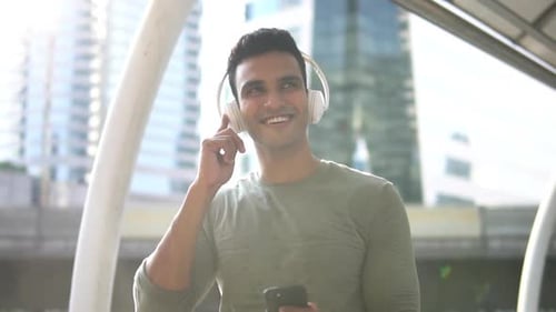 Man Listening to Music with Headphones in City