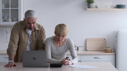 Couple Using Laptop in Modern Kitchen Setting