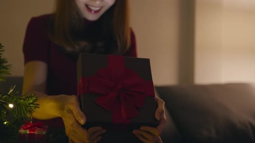 Woman Receives Christmas Gift with Joyful Expression