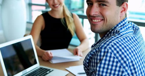 Executives smiling at desk in office