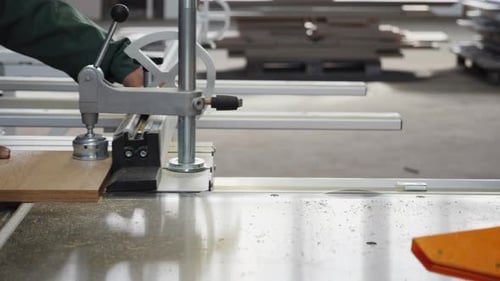 Les travailleurs de l'atelier utilisent une scie à bois industrielle