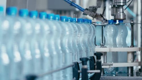 Bouteilles d'eau se déplaçant sur une ligne de convoyeur automatique dans une usine de production