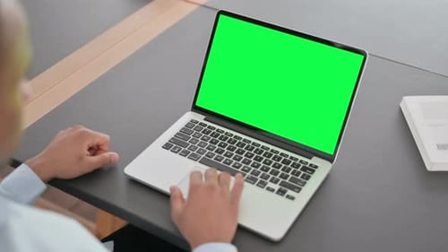African Man Using Laptop with Green Chroma Key Screen