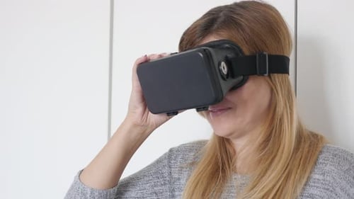 Caucasian woman trying virtual reality 360 glasses in living room 4K 2160p 30fps UltraHD footage -