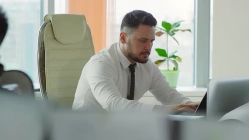 Man Working on Laptop in Modern Office