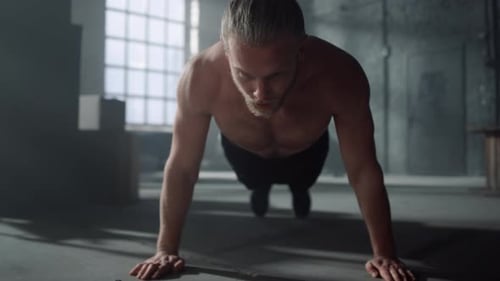 Man Doing Push Ups on Floor in Gym