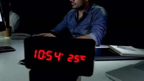 Homme accro au travail faisant des heures supplémentaires tard dans la nuit au bureau travaillant sur un ordinateur