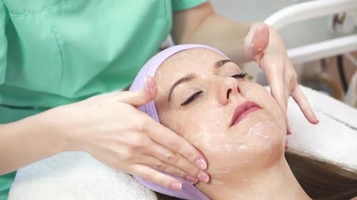 Frau bekommt eine Spa-Massage. Schöne junge Frau bei Gesichtsmassage im Kosmetiksalon