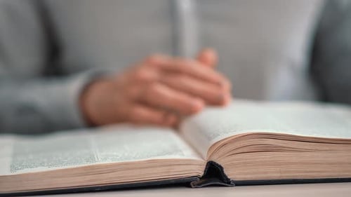 Nahaufnahme Nicht wiederzuerkennender Mann liest Vintage-Buch Umblättern Papierseiten auf dem Schreibtisch in der öffentlichen Bibliothek
