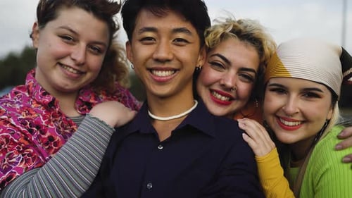 Smiling Young Adults Embrace in a City