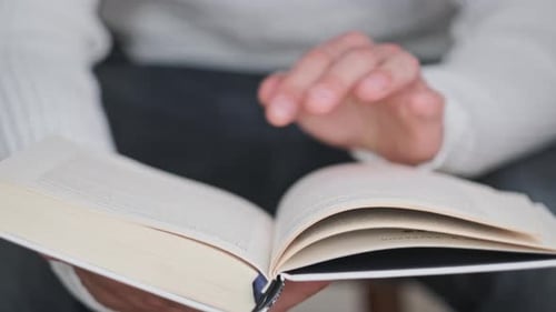 Junger Mann liest ein Buch und blättert Seiten um Nahaufnahme Zeitlupe