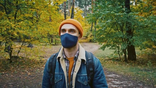 Young Tourist Man Walking in Forest Wearing Medical Protective Mask Safe Travel Hiking in Park Slow