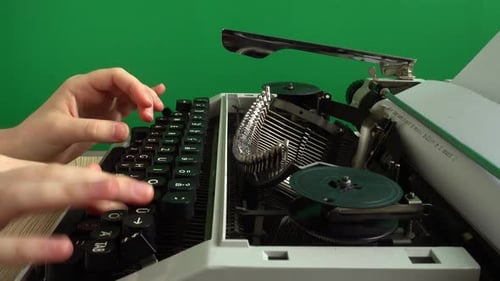 The girl is typing on a retro typewriter on a green background. Chromakey.