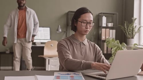 Adults Collaborate at Desk in Modern Office