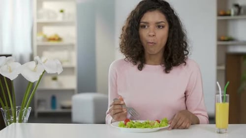 Woman Eating Salad Indoors at White Table