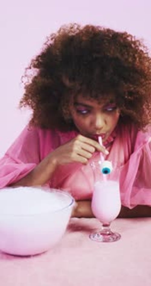 Woman Drinks Pink Milkshake with Decorative Eyeball