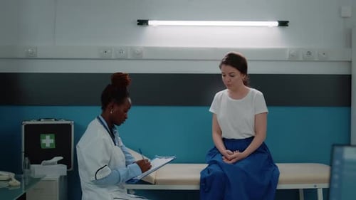 African American Medic Consulting Patient in Doctors Office