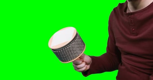 Mid section of male musician playing cabasa