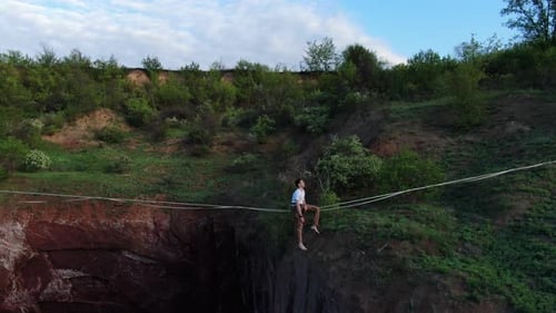 Man Balancing on Tightrope Over Canyon