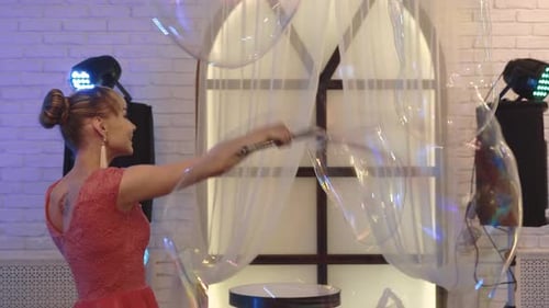 Woman Creates Giant Bubbles on Stage at Party