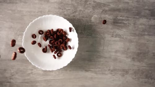 Chocolate Loop Cereal Falling Into White Bowl