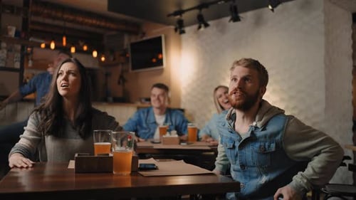 Friends and Fans Rejoice Together Emotionally Watching Football on TV in a Bar and Celebrating the