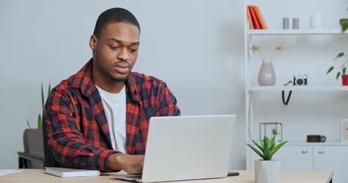 Young Adult Working on Laptop at Home Office