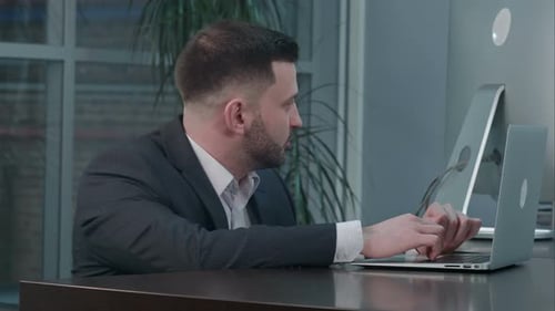 Man Typing on Laptop at Desk in Office