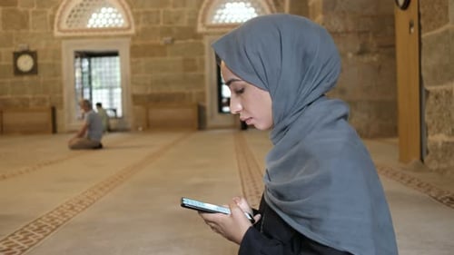 Betet in der Moschee Junge muslimische Frau liest islamisches Holybook-Smarthphone