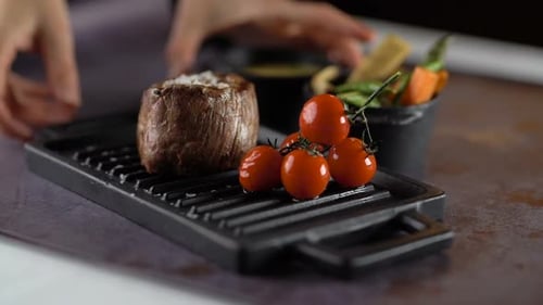 Delicious Steak Served on Grill Plate with Tomatoes