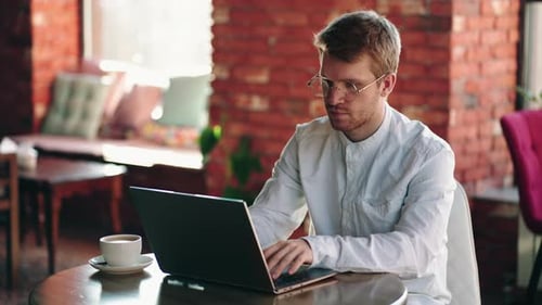 Empresario centrado hombre de negocios escribiendo en portátil haciendo investigación