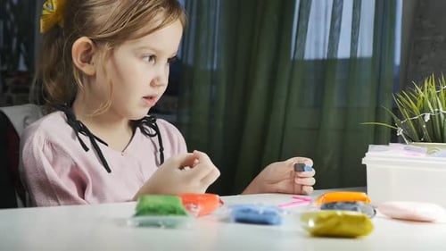 Girl Creates Art with Colorful Clay Indoors