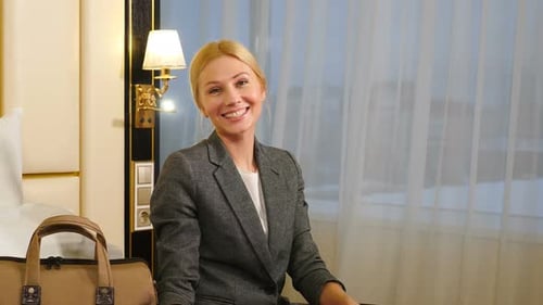 Smiling Woman in Hotel with Bright Light Outside