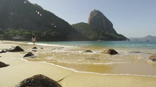 Slow motion shot of a woman walking along Red Beach in Rio.