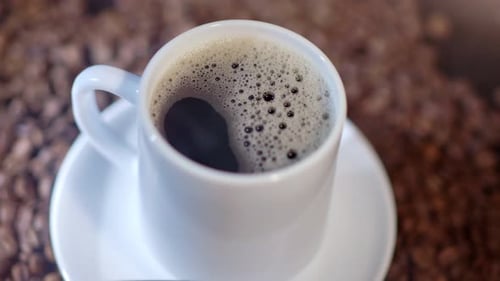 A Cup of Strong Coffee is in a Cup Among Organic Arabian Coffee Beans
