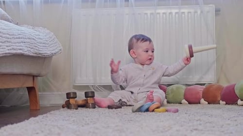 Cute Infant Plays With Wooden Toys on Carpet