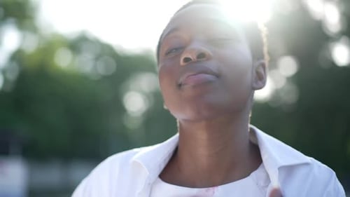 Smiling Person Blowing a Kiss Outdoors in the Sun